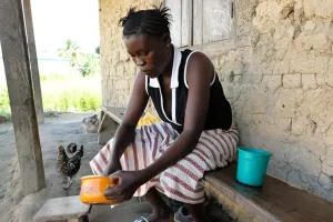 Fanta, a young lady, washes dishes. 