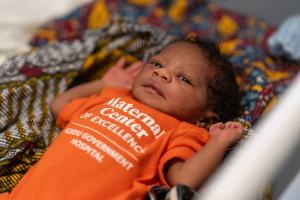 newborn lying in baby cot 