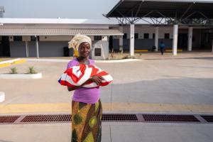 Jeneba Koroma holding a baby outside the MCOE