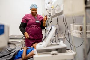 Nurse Moinya Lukulay tends to patient Augusta Allieu in the triage area