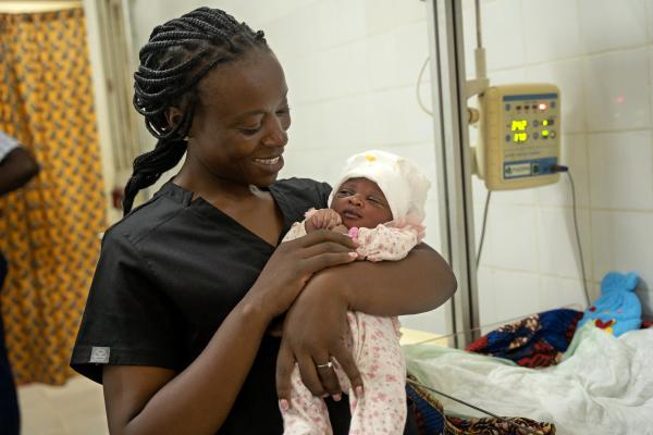 Midwife holds baby in her arm
