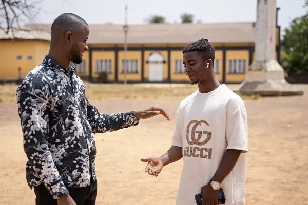Two young men smiling about to shake hands
