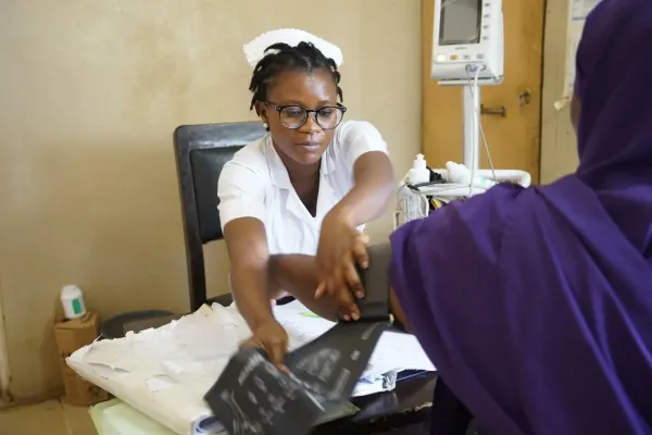 Midwife measures a patient's blood pressure.