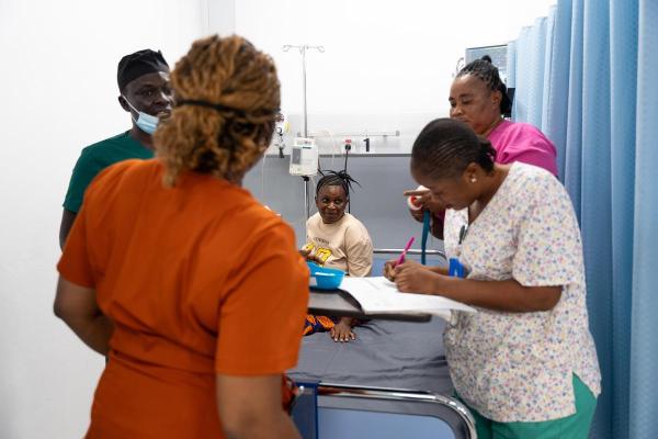 Staff and patient Fatmata Jalloh in the triage area of the MCOE