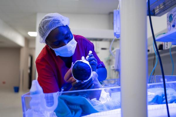 Alice Posseh Yarbom Tenner feeds a newborn in the NICU