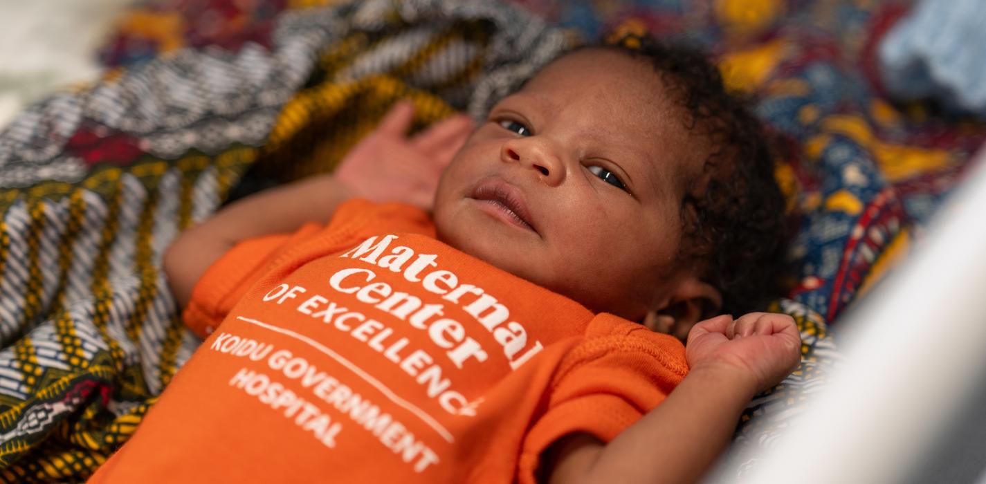 newborn lying in baby cot 
