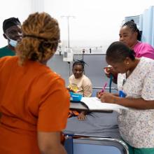 Staff and patient Fatmata Jalloh in the triage area of the MCOE