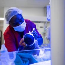 Alice Posseh Yarbom Tenner feeds a newborn in the NICU