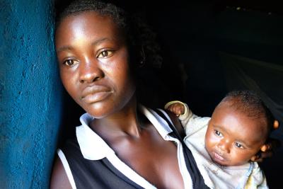 Fanta holds her baby in a doorway.