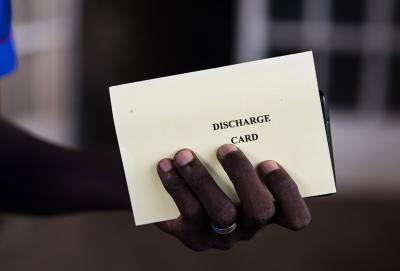 A hand holding a discharge card
