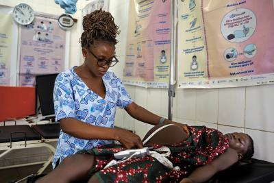 Midwife is measuring the belly of a pregnant woman with a tape measure