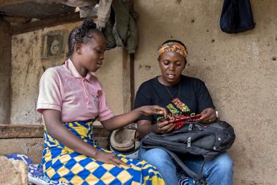 Two women sitting outside a house looking at medication