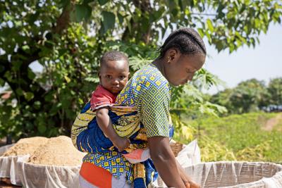 Abibatu Fofanah and her son Ibrahim take part in making Bennimix at Wellbody Clinic. The nutritious blended meal is designed for infants and children to combat malnutrition.