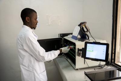 man in lab placing sample in analytics machine