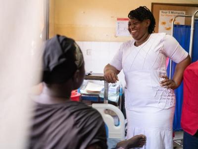 nurse standing next to woman in hospital bed