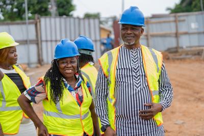 Woman and man in hard hats and visibility vests at construction site