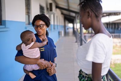 Midwife holding baby girl at clinic