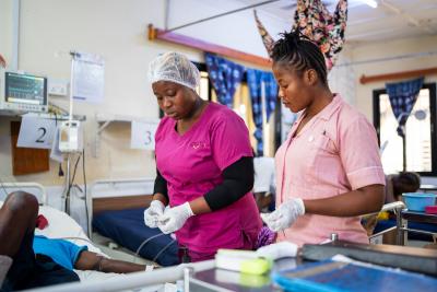 two nurses working next to a patient bed