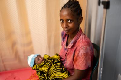 woman holding her baby sitting in a hospital