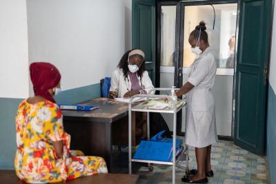 Dr. Suba M'bayo (middle) and Ministry of Health nurse Adama Bagoley (right) provide medication to Jemilatu Jalloh (left).
