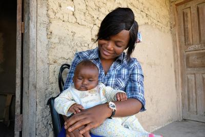 A midwife holds a baby at a home visit