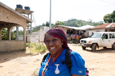 Isata, a clinician, standing outside