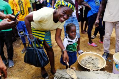 PIH Physician Dr. Aramide Oteju lays a brick at MCOE