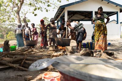 Women cooking over a pot