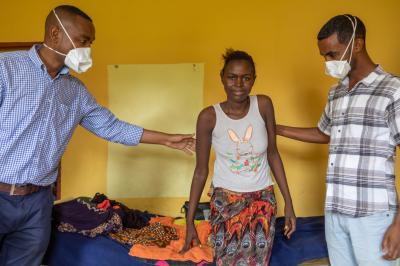 Two doctors assist Sesay as she stands up