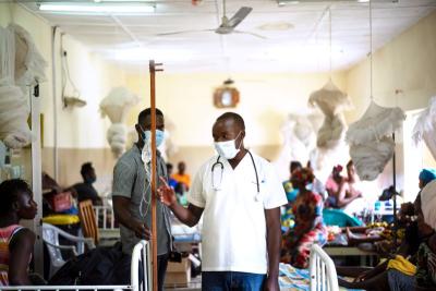 A doctor walks through a ward and talks to patients