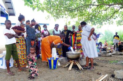 A woman watches as mothers prepare Bennimix