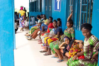 Women sit outside a waiting area