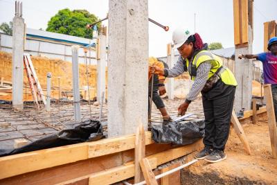 Diana "Success" Komba takes measurements for rebar placement at the MCOE construction site