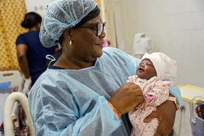 A clinician holds a newborn baby