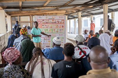 A nurse stands in front of a group of patients and leads a discussion