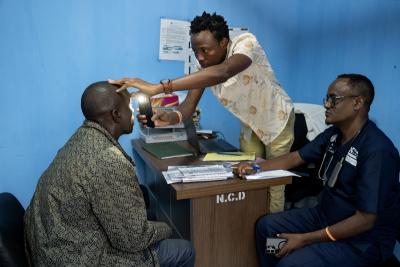 A clinician is examining a patient with a phone light