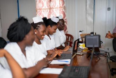 Gladyse A. Kanu, Isata Bah, and Francess Kamara in a classroom using computers