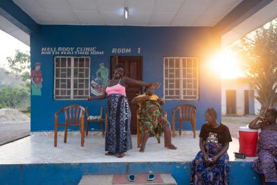 Expectant mothers Finda Lahai, Finda Boyah, Fatmata Jalloh, and Mariatu Koroma listen to music and dance on the porch of the maternal waiting home