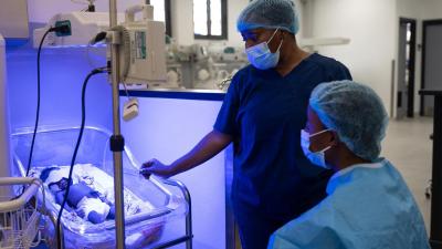 Phebian Baningo sitting next to her daughter's cot in the NICU.