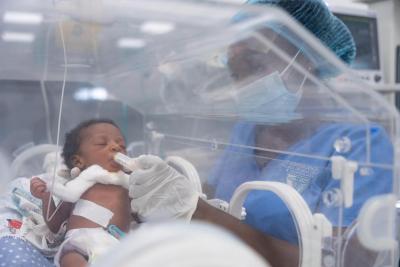 Daniella Jabati feeds newborn in an incubator in NICU