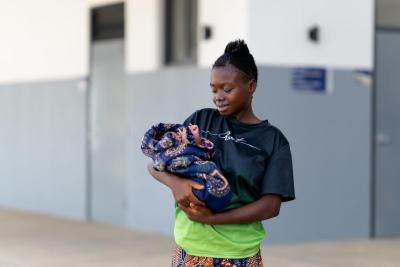 Fanta Jimmy holds her newborn daughter outside of the MCOE
